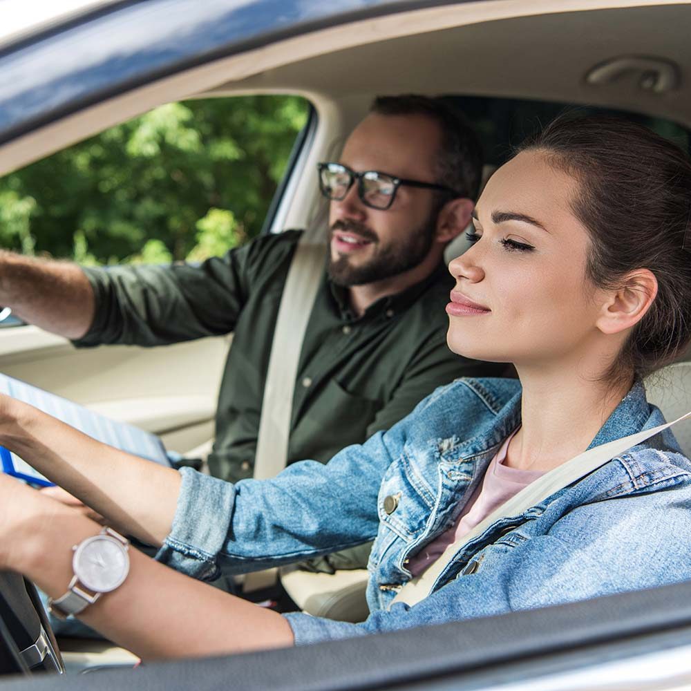 cheerful-student-and-teacher-in-car-at-driving-tes-8WUZ9MG.jpg